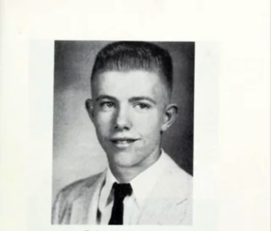 Black and white yearbook portrait of a young man with short, neatly combed hair, wearing a light-colored jacket, white shirt, and dark tie, smiling slightly at the camera.