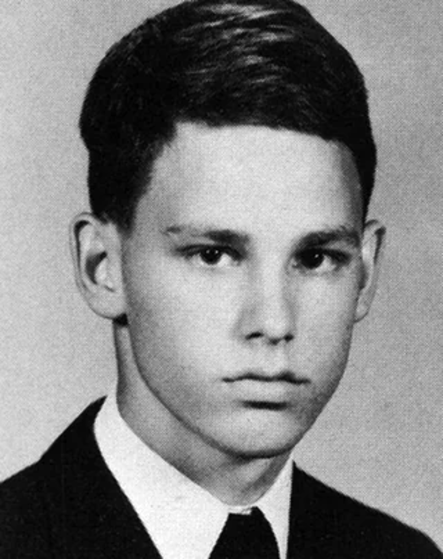 Black and white yearbook portrait of a young man with short dark hair, wearing a suit jacket, white shirt, and thin tie, looking seriously at the camera against a plain background.