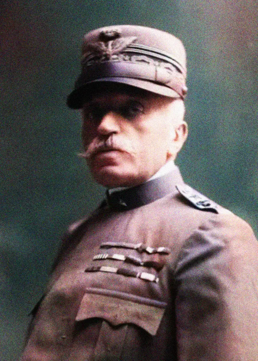 A sepia-toned portrait of a military officer in uniform with a cap, mustache, and several medals and decorations on his chest, posed against a plain background.