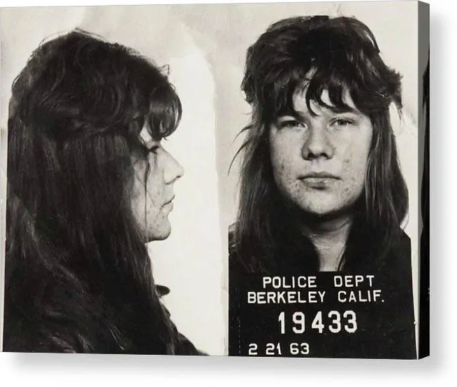 Black and white mugshot of a long-haired individual, shown in profile and front view, holding a placard labeled "POLICE DEPT BERKELEY CALIF. 19433 2 21 63.