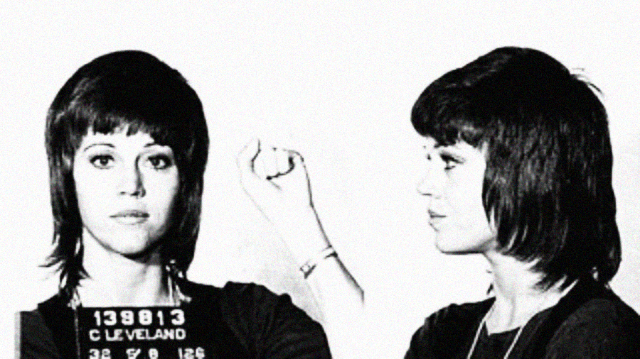 Black and white mugshot photo of a woman with short dark hair. She holds up her clenched fist in defiance, looking forward in one image and to the side in the other. A number plate marked "139813 CLEVELAND" is visible.