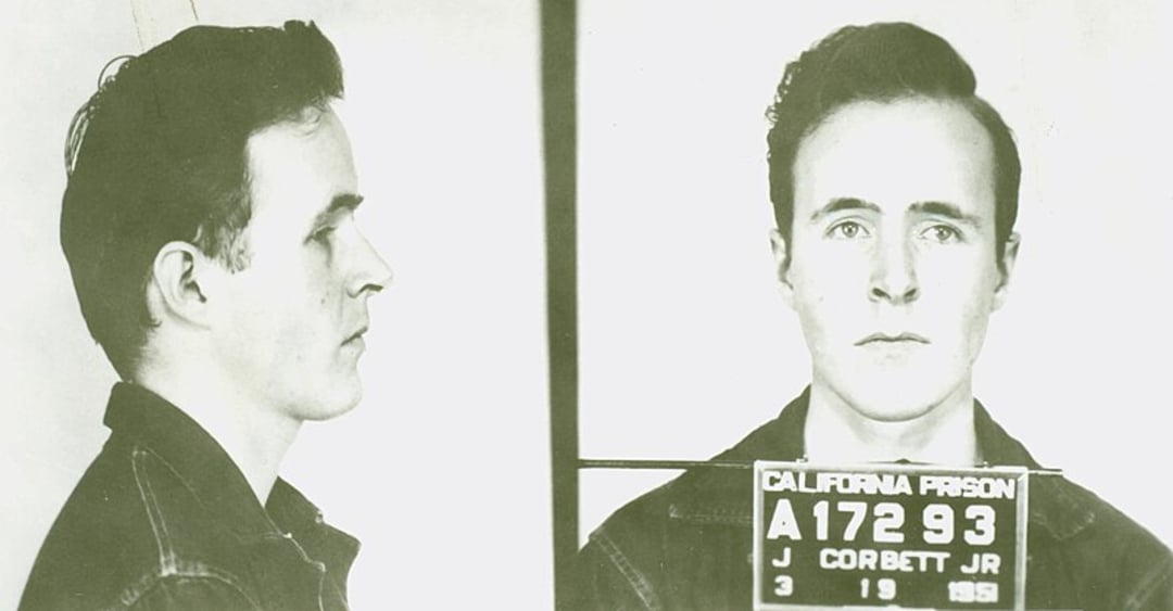 Black-and-white mugshot of a young man with short hair, seen in both profile and front views, wearing a jacket. He holds a placard showing "California Prison" and identification details.