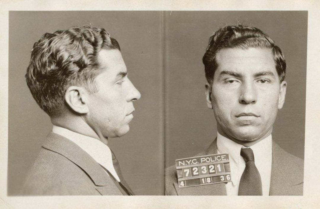 Black and white mugshot of a man in a suit and tie, shown from the side and front. He is holding a placard with "N.Y.C. POLICE" and the number 72321, dated 4-18-36.