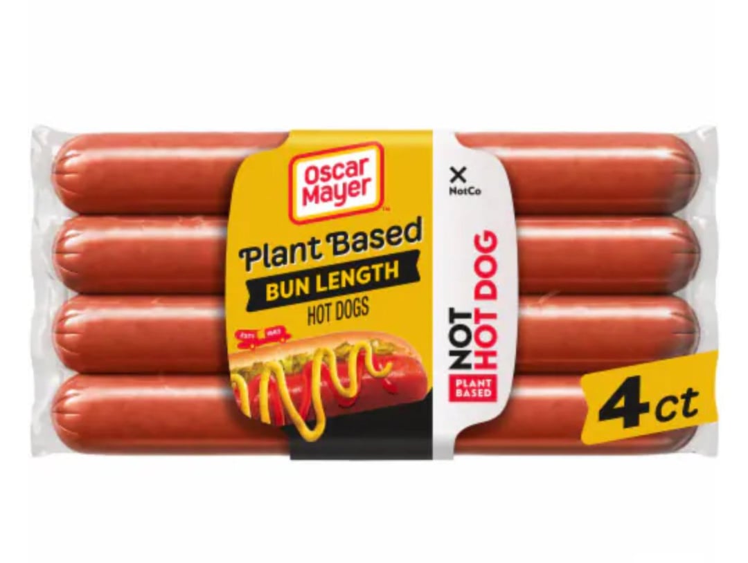 A package of Oscar Mayer Plant Based Bun Length Hot Dogs, containing four hot dogs. The label highlights "Plant Based" and "Not Hot Dog" with an image of a hot dog topped with mustard.
