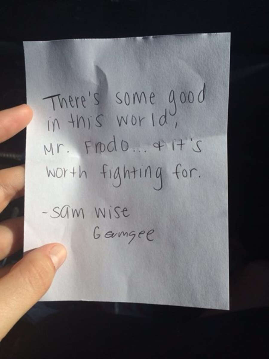 A hand holds a note that reads: "There's some good in this world, Mr. Frodo... and it's worth fighting for. - Samwise Gamgee.