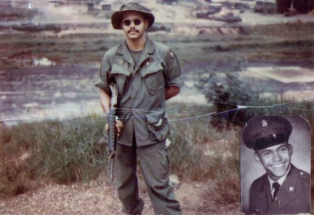 A soldier in jungle fatigues, sunglasses, and a boonie hat stands holding a rifle outside. An inset black-and-white portrait in the lower right shows the same man in formal military uniform, smiling.