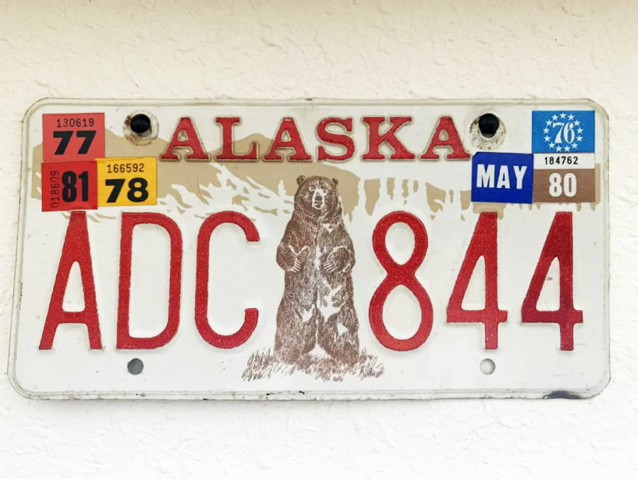An Alaska license plate featuring a standing brown bear in the center, large red letters and numbers "ADC 844," and registration stickers for the years 1977, 1978, 1980, and 1981.
