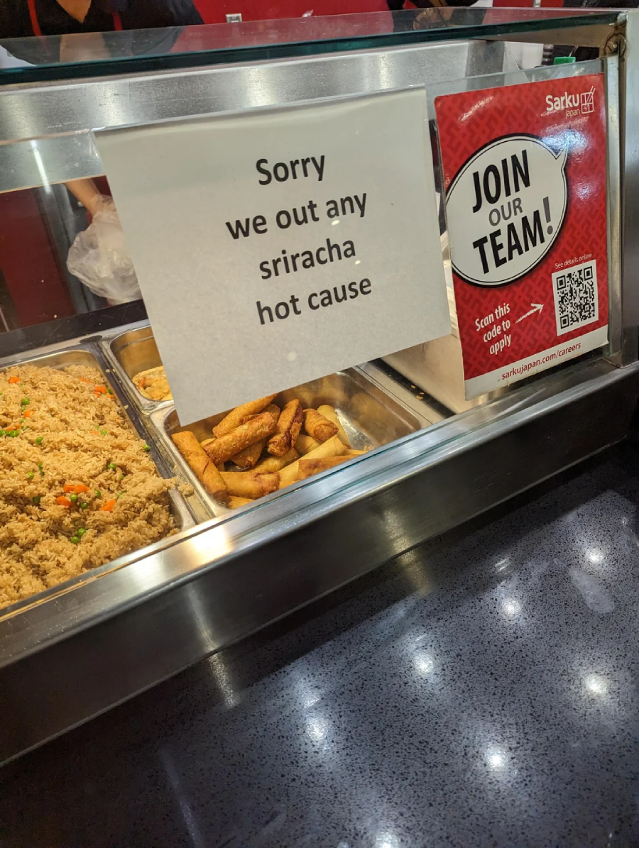 A sign at a food counter reads, "Sorry we out any sriracha hot cause." Trays of fried rice and egg rolls are visible behind the glass. A "Join Our Team!" recruitment poster is on the counter.
