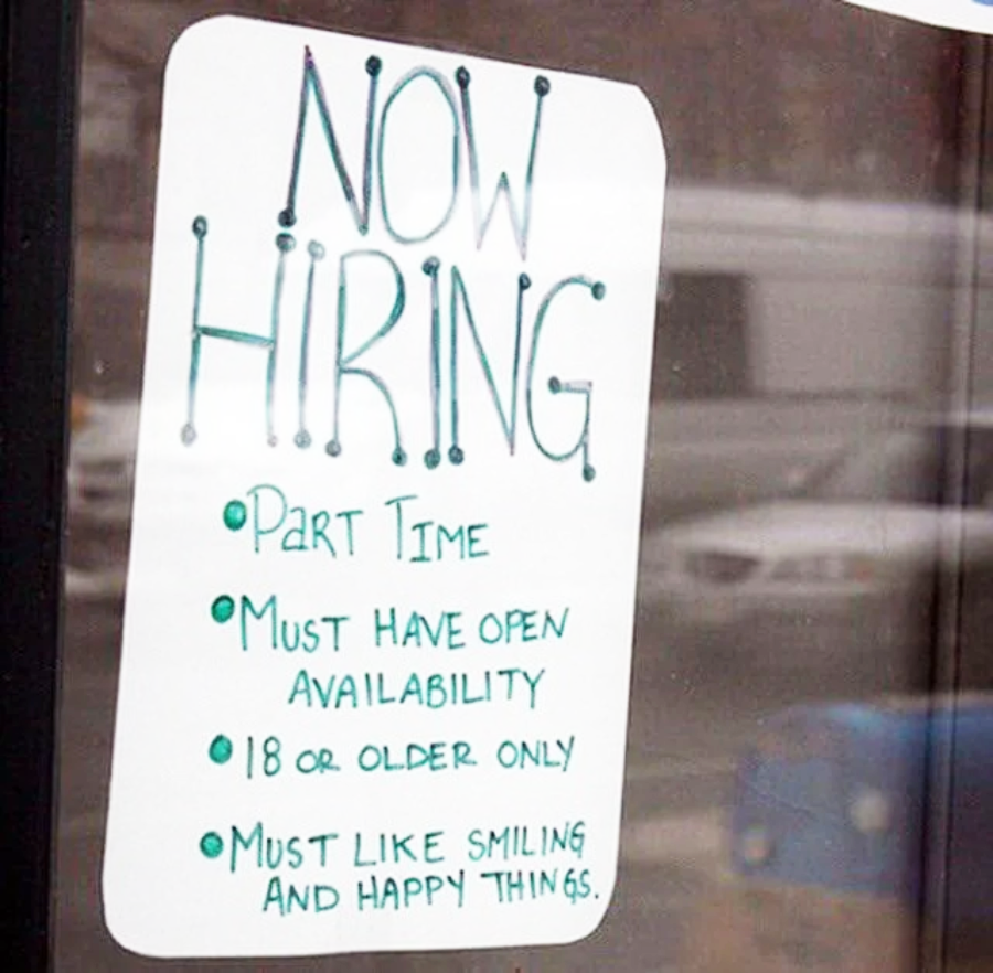 A handwritten sign on a window reads: "Now Hiring. Part Time. Must have open availability. 18 or older only. Must like smiling and happy things.