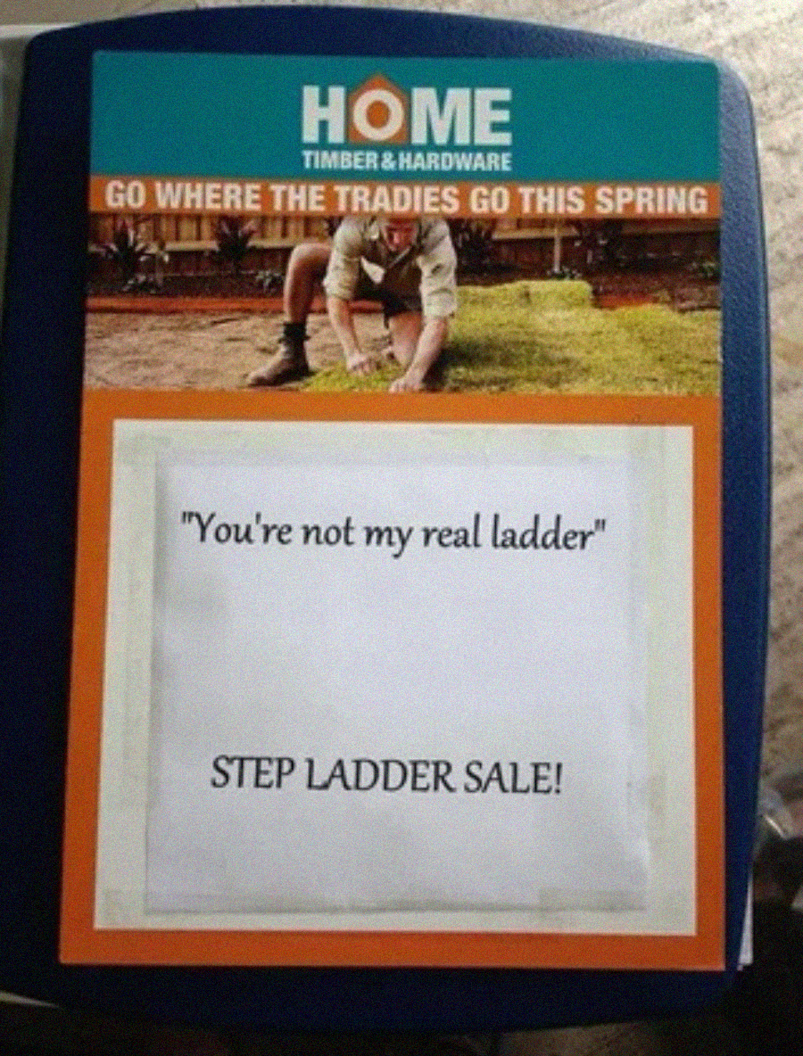 A sign for Home Timber & Hardware shows a worker laying turf. Below, text reads: "You're not my real ladder" and "STEP LADDER SALE!" as a play on words referencing 'step ladder.'