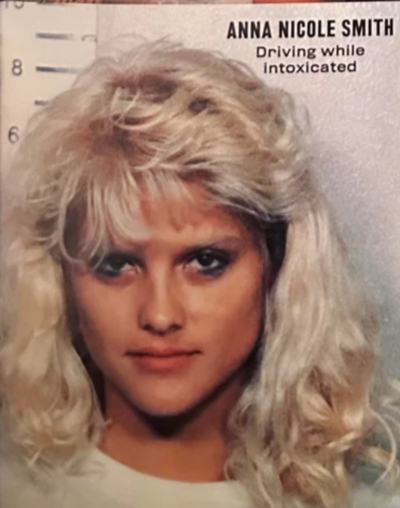 A woman with long, wavy blonde hair stands in front of a height chart for a mugshot. Text in the top right reads, "ANNA NICOLE SMITH Driving while intoxicated.