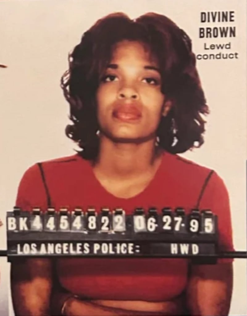 A woman in a red top sits for a police mugshot. The board reads "LOS ANGELES POLICE: HWD" with a booking number and the date 06-27-95. The text "DIVINE BROWN Lewd conduct" appears in the top right corner.