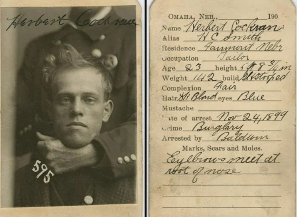 A vintage mugshot of Herbert Cockran with identifying information handwritten beside his photo, detailing his physical traits, alias, occupation, and criminal record. A hand holds his chin in the photograph.