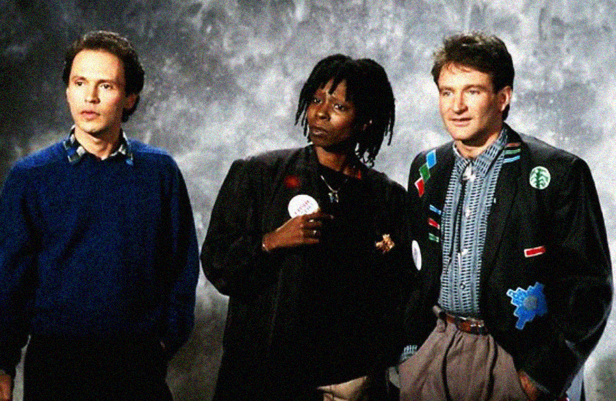 Three people stand side by side against a gray backdrop. The person on the left wears a blue sweater, the person in the middle wears a black jacket, and the person on the right wears a patterned jacket over a shirt and tie.