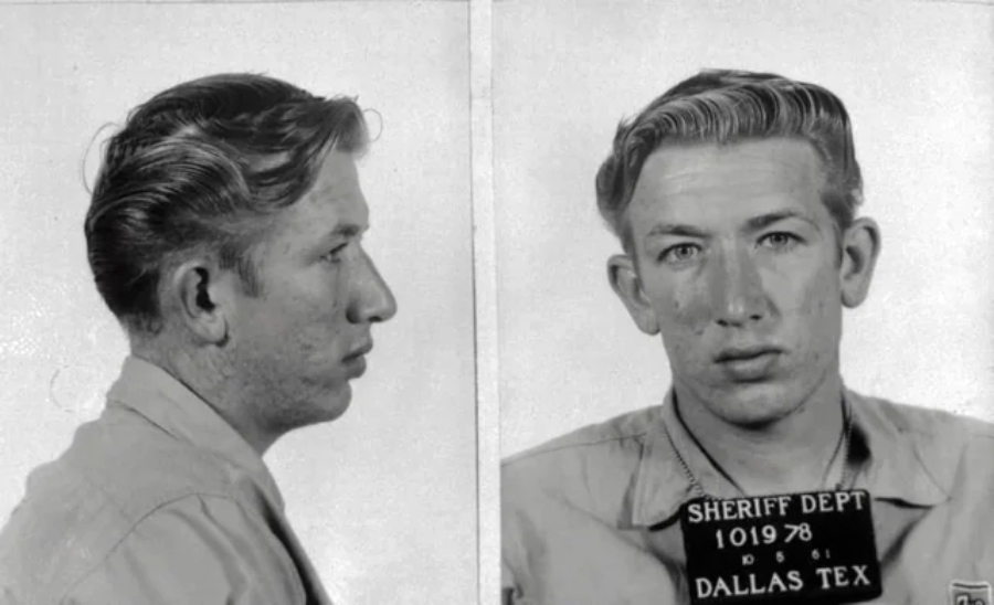 Black-and-white mugshot showing a young man with light hair in two views: side profile and facing forward. He holds a sign reading "Sheriff Dept Dallas Tex 101978" in the front-facing photo.
