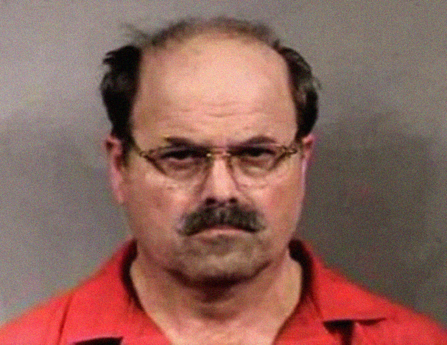 A man with a mustache and glasses