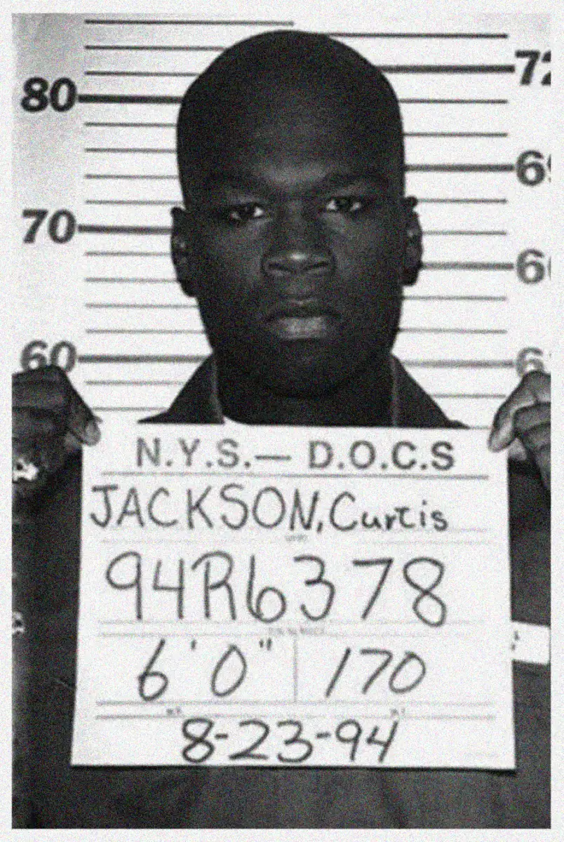 Black and white mugshot of a man holding a sign reading "N.Y.S. - D.O.C.S. Jackson, Curtis 94R6378, 6'0", 170, 8-23-94" in front of a height chart.
