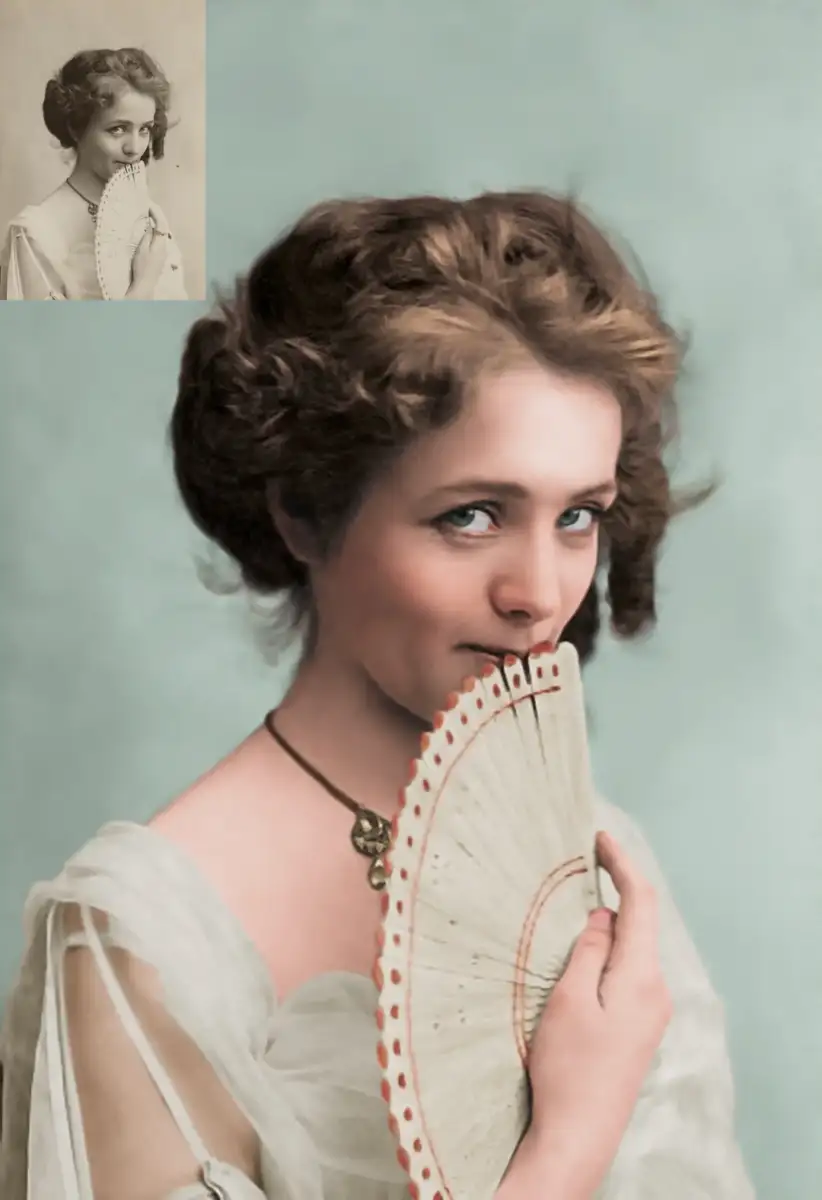 A woman with wavy brown hair holds a white fan near her mouth, wearing a sheer dress and necklace, gazing softly at the camera. In the top left, a sepia inset shows the same pose in black and white.