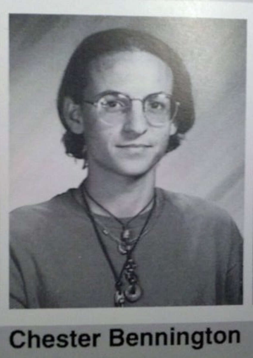 Black and white yearbook photo of a young person with glasses, shoulder-length hair, and wearing layered necklaces and a t-shirt. The name "Chester Bennington" is printed below the image.