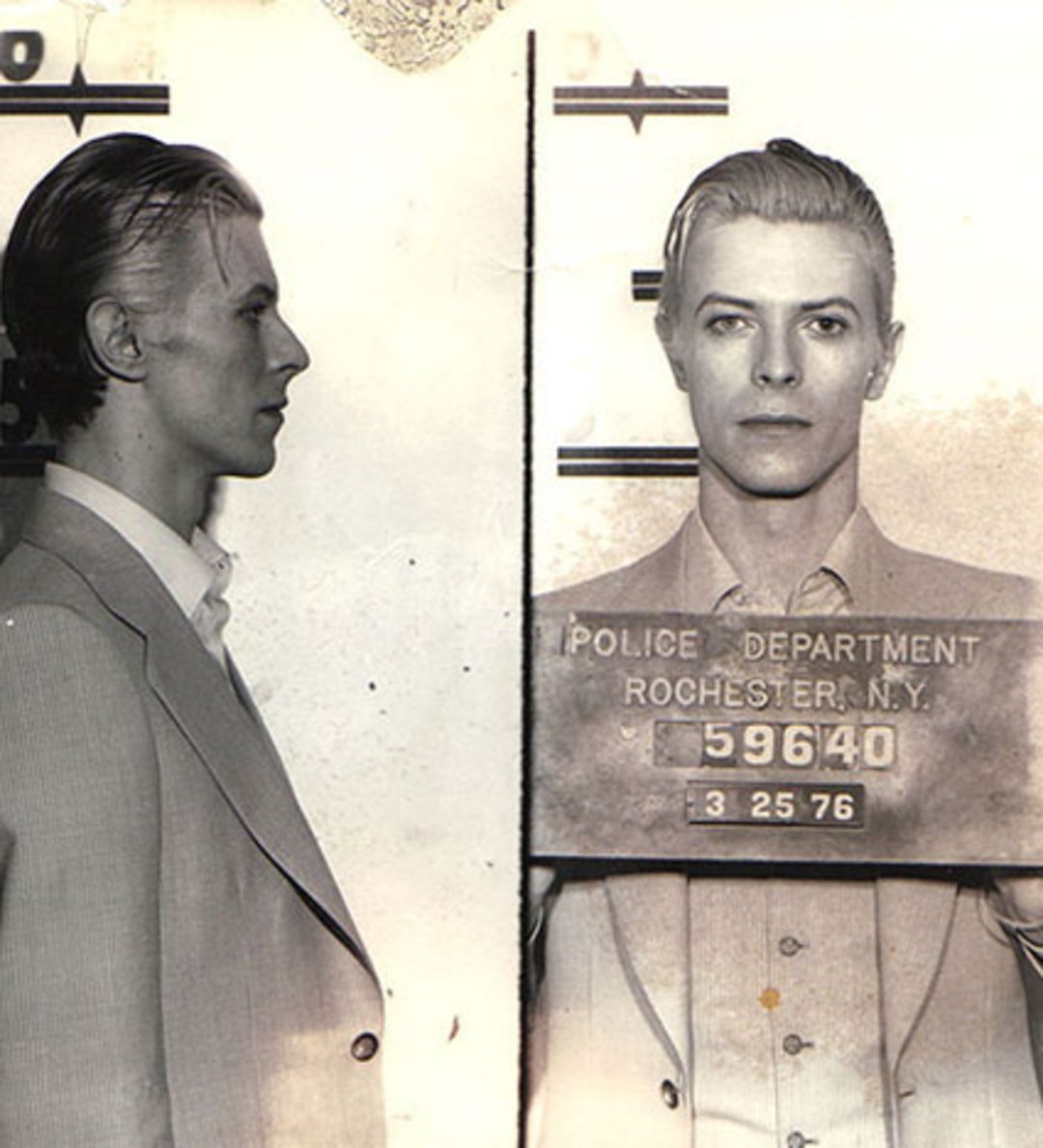 Black and white mugshot of a man in a suit with slicked-back hair, shown in side and front views. He holds a sign reading "Police Department Rochester N.Y. 59640, 3 25 76.