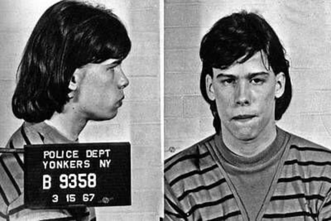 A black-and-white mugshot shows a young person with medium-length dark hair wearing a striped sweater, photographed from the side and front. A placard reads “Police Dept Yonkers NY” with an ID number and date.