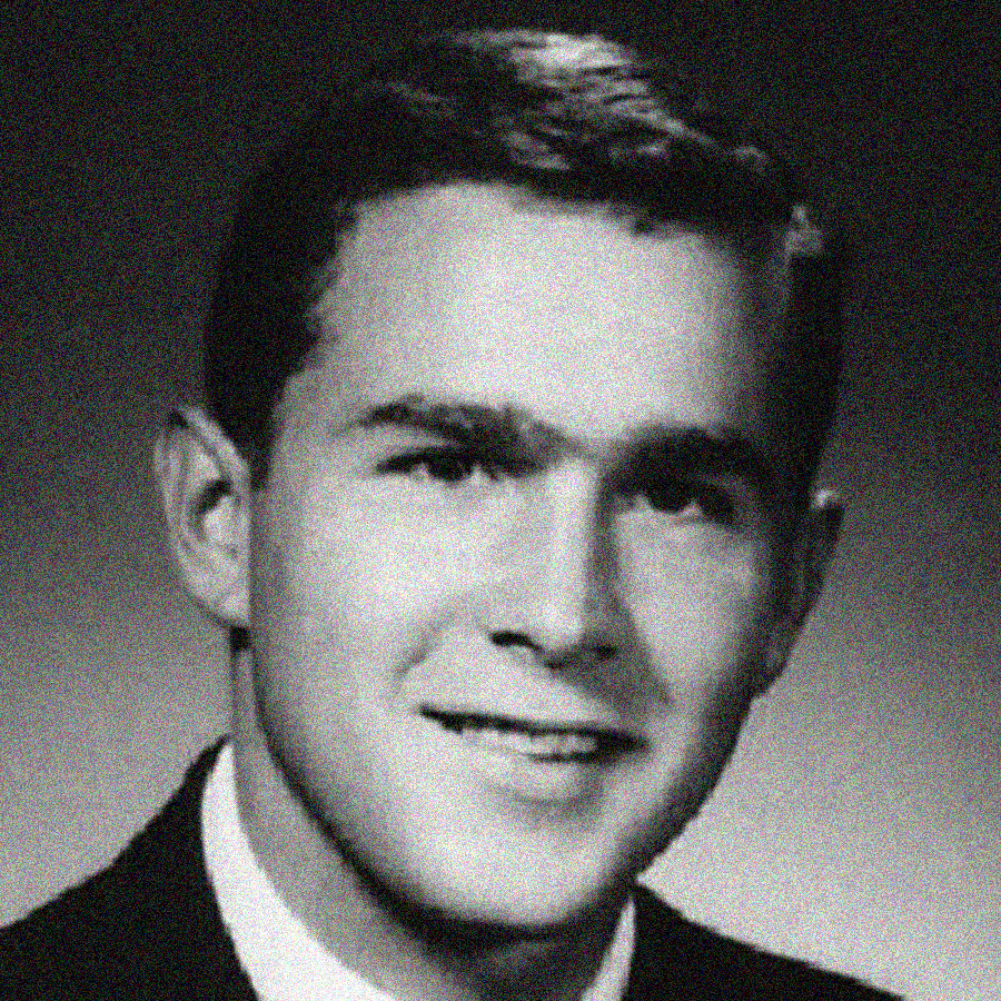 Black and white portrait of a young man with short hair, wearing a suit and tie, smiling slightly and looking at the camera.