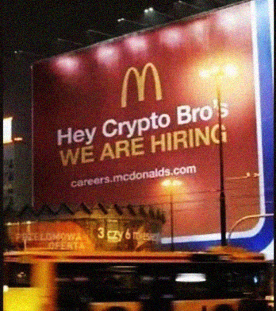A large McDonald's billboard at night reads "Hey Crypto Bros, WE ARE HIRING" with the website careers.mcdonalds.com beneath the text. A bus drives past in the foreground.