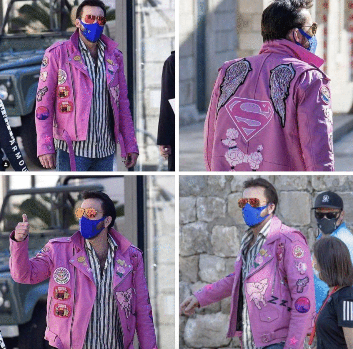 A man wearing a bright pink jacket with various patches, including wings and a large Superman logo on the back, blue face mask, sunglasses, and striped shirt, is seen walking and gesturing outdoors.