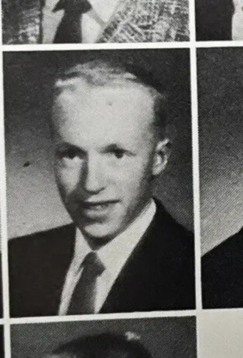 Black-and-white yearbook portrait of a young man wearing a suit and tie, looking at the camera with a slight smile, against a plain background.