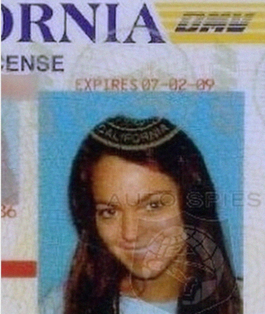 A close-up of a California driver's license showing a woman with long dark hair smiling in her ID photo. Some text and security markings are visible, with an expiration date of 07-02-09.