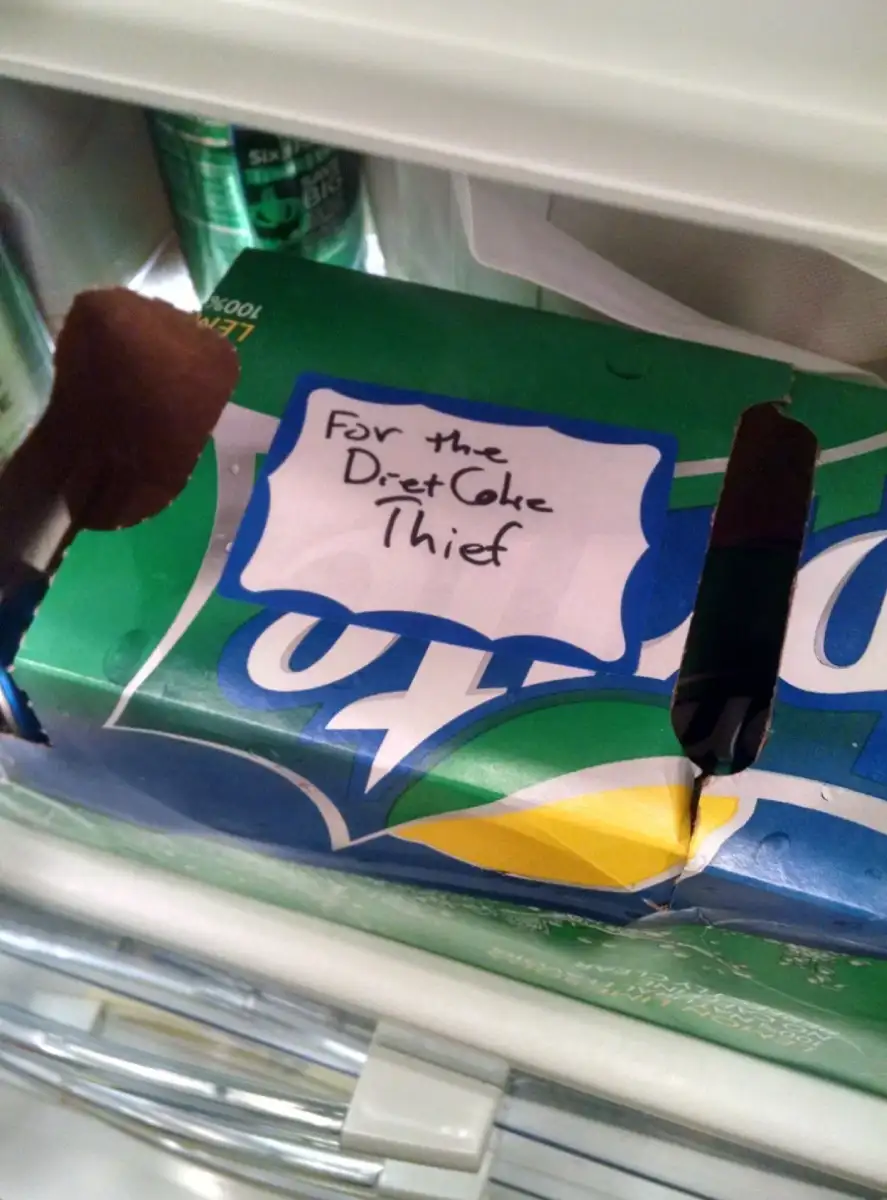 A Sprite box in a fridge has a handwritten label reading, "For the Diet Coke Thief." The box appears to be hiding something inside, likely intended as a humorous message to someone stealing Diet Coke.