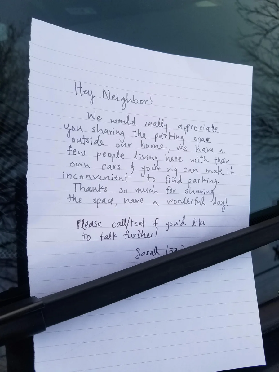 A handwritten note is placed under a windshield wiper. The note politely asks a neighbor to avoid parking outside the writer’s home, as it makes parking difficult for residents. A contact number is provided at the end.