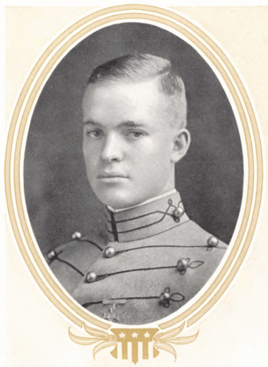 Black-and-white portrait of a young man in a formal military uniform with decorative buttons and braiding, inside an oval frame with a gold border and shield design at the bottom.