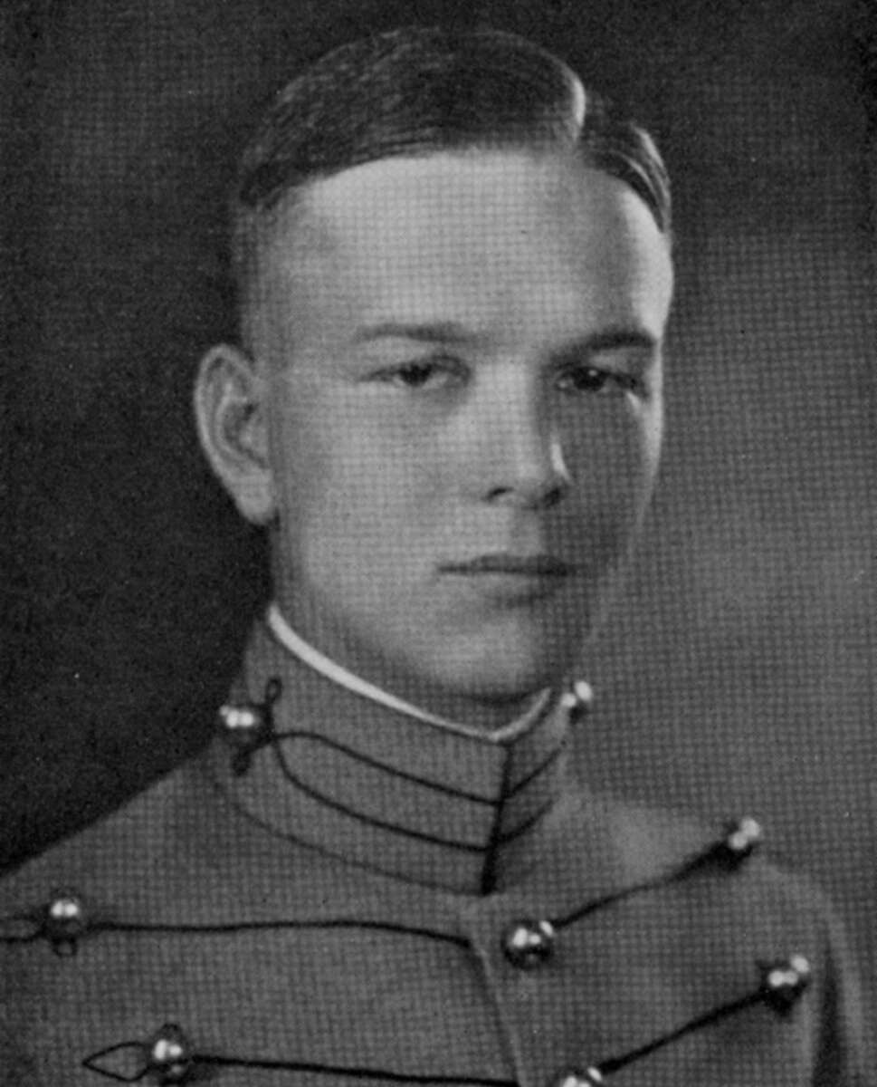 Black and white portrait of a young man wearing a formal military uniform with decorative buttons, short neat hair, and a serious expression, posing against a plain background.