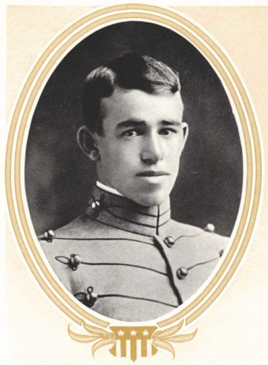 Black-and-white portrait of a young man in a military cadet uniform, framed by an oval border with a decorative design at the bottom. The young man has short dark hair and a calm expression.