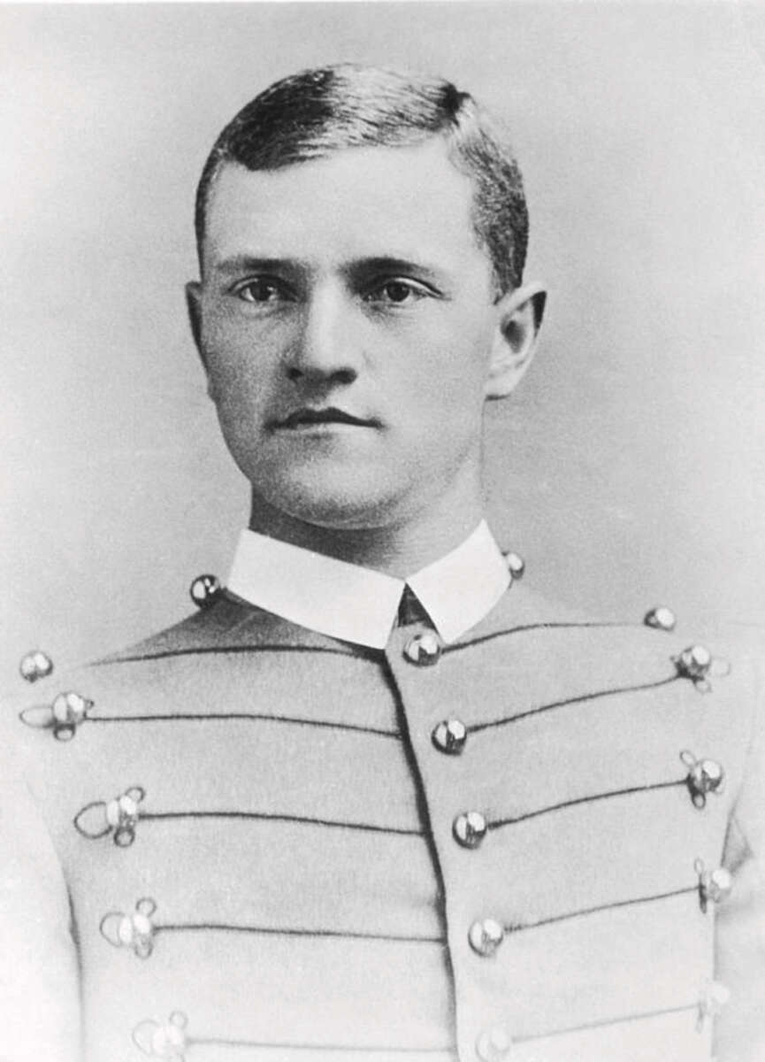 Black and white portrait of a young man with short hair, wearing a formal military uniform with decorative buttons and a high collar, looking slightly past the camera with a neutral expression.