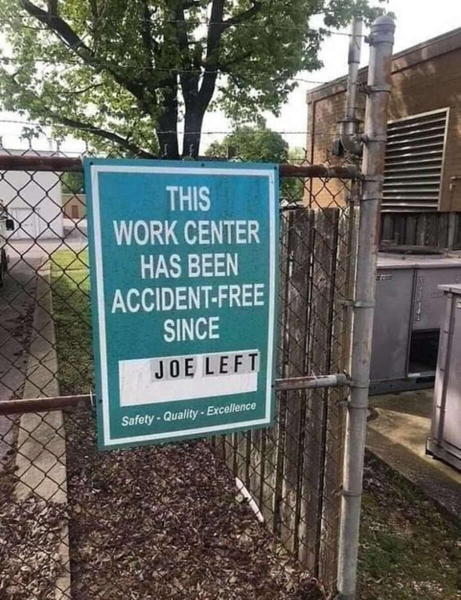 A sign on a chain-link fence reads, "THIS WORK CENTER HAS BEEN ACCIDENT-FREE SINCE JOE LEFT," with "JOE LEFT" replacing the usual date. The sign emphasizes safety, quality, and excellence.
