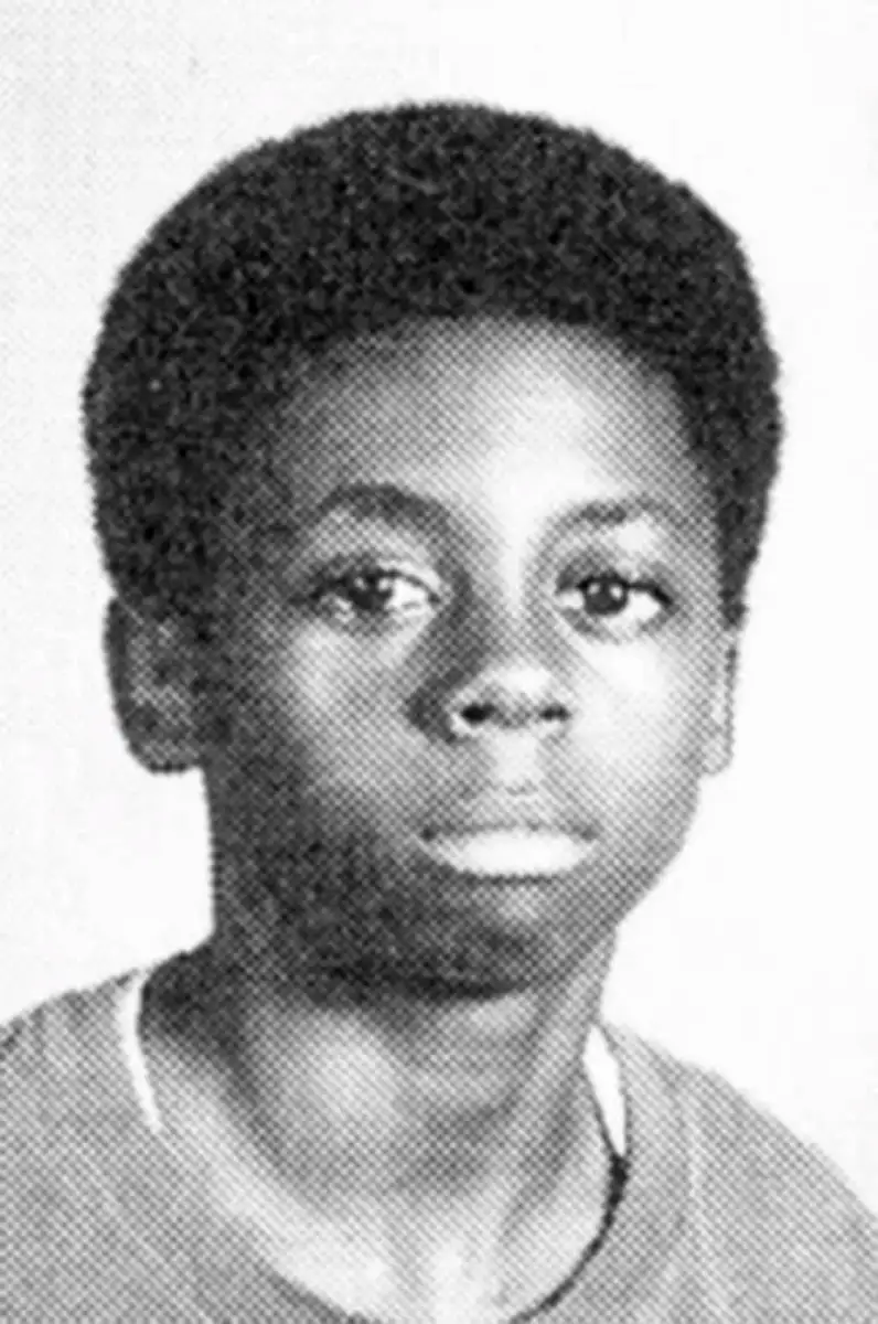 Black and white yearbook-style portrait of a young boy with short curly hair, looking directly at the camera with a neutral expression, wearing a light-colored shirt.