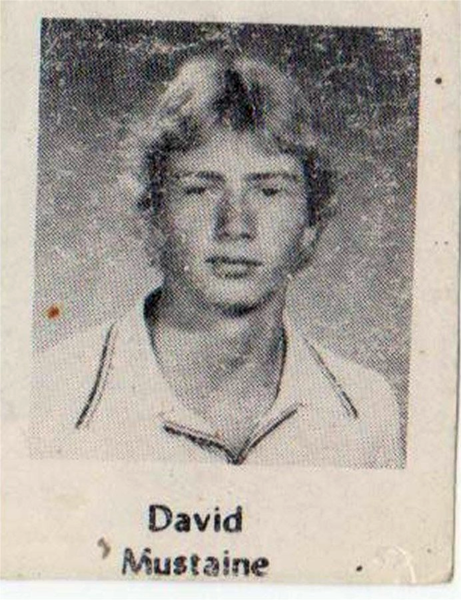 A black and white yearbook photo of a young person with light hair, wearing a collared shirt. The name "David Mustaine" is printed below the image.