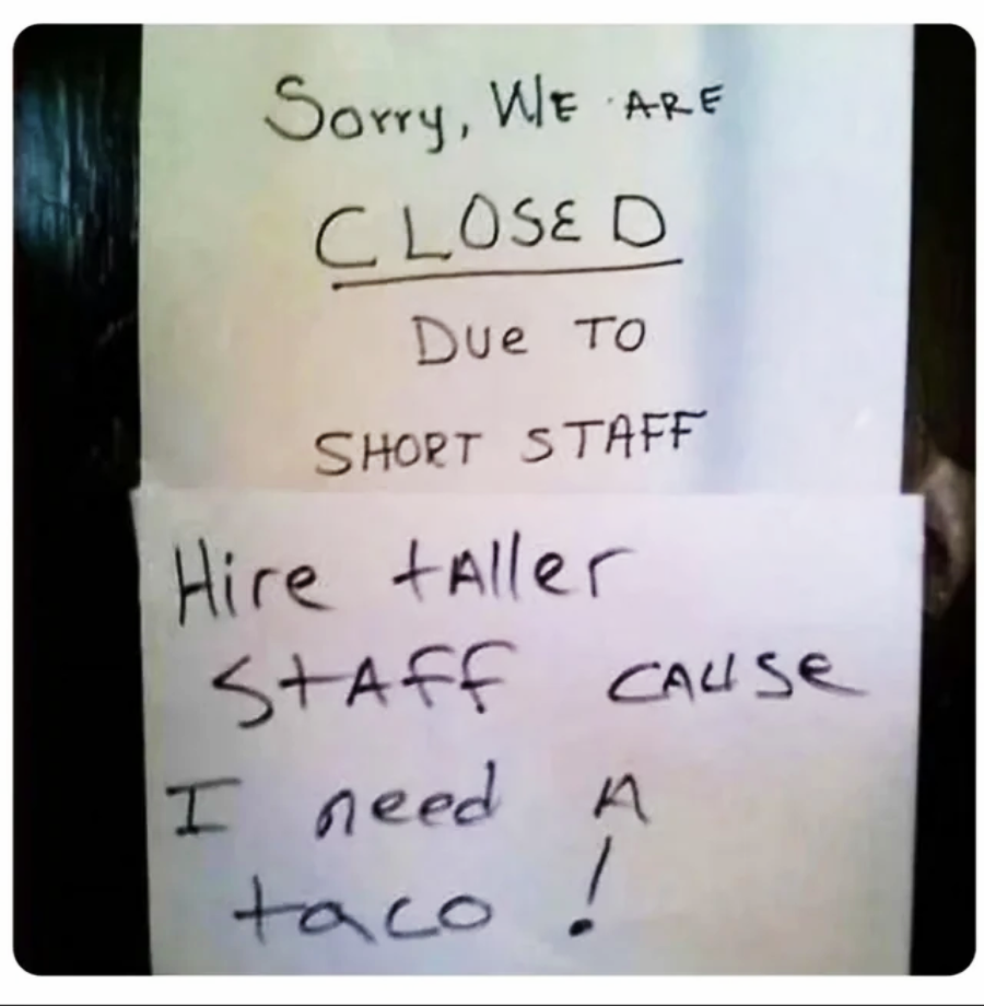 Two handwritten signs: The top sign says they are closed due to "short staff." The bottom sign jokes, "Hire taller staff cause I need a taco!" referencing the phrase "short staff.