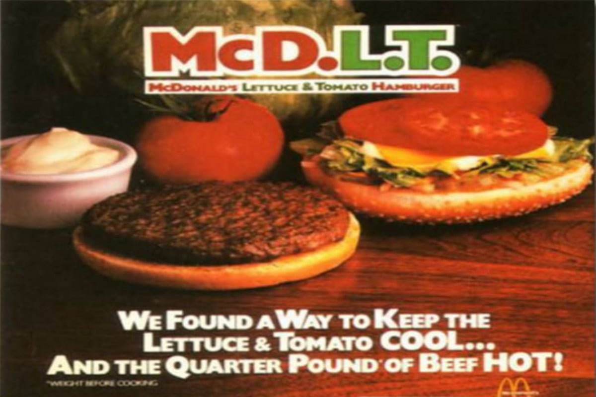 An advertisement for the McDonald’s McDLT burger shows a separated hamburger bun with lettuce, tomato, and condiments on one half, a cooked beef patty on the other, and text highlighting “cool” vegetables and “hot” beef.