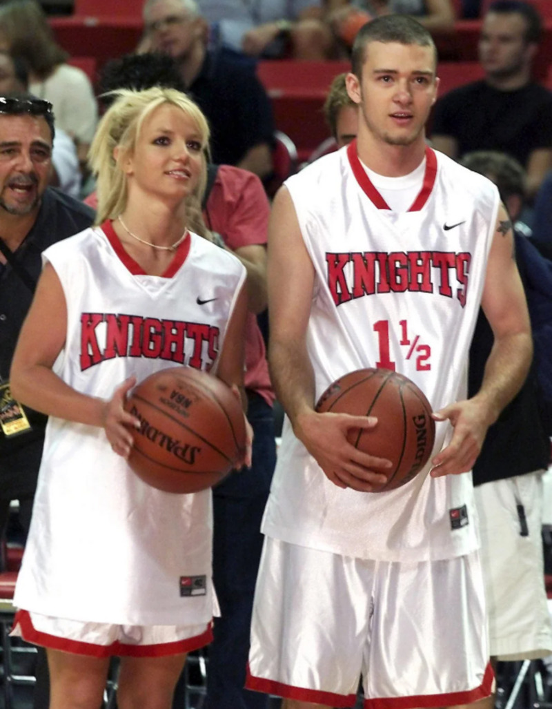 Two people wearing matching white basketball uniforms labeled "Knights" stand side by side holding basketballs. They are on a court with spectators in the background.