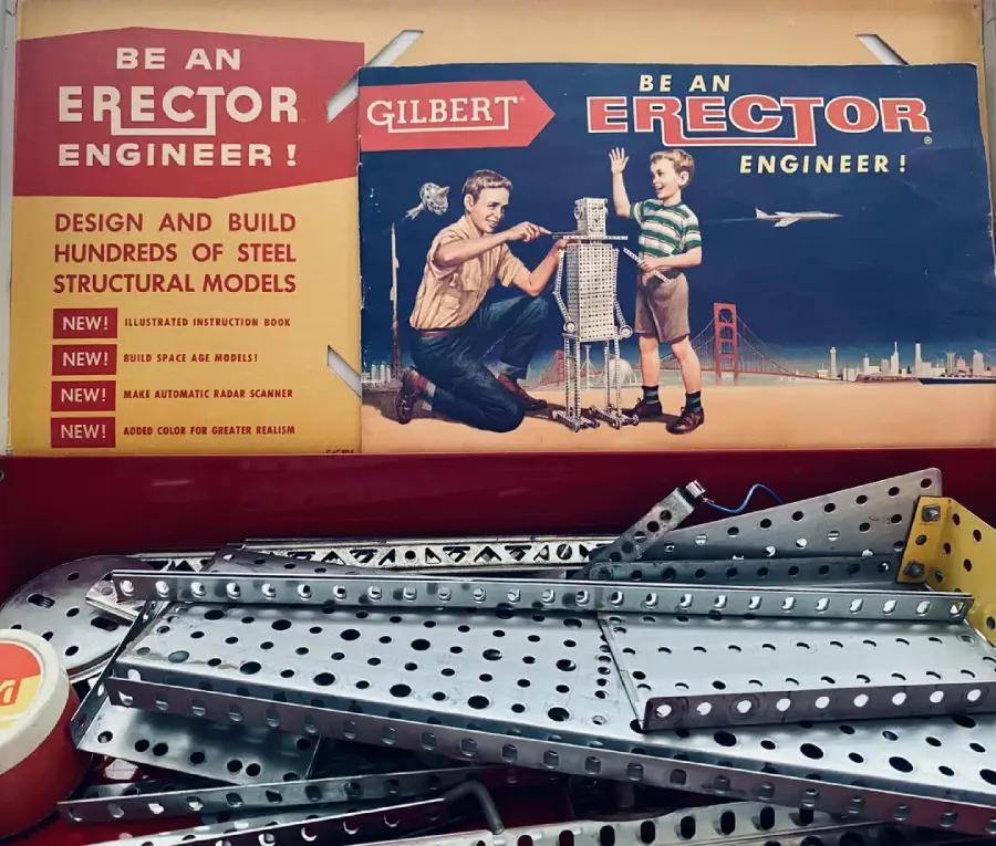 Vintage Erector Set box featuring an illustration of a man and boy building a metal structure, with metal strips and parts visible below. The box promotes engineering and building steel structural models.