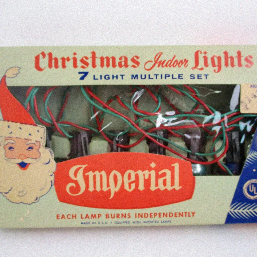 Vintage box of "Imperial" Christmas indoor lights, featuring a smiling Santa illustration, red and green light wires visible in the window, and the text “7 Light Multiple Set” on the packaging.