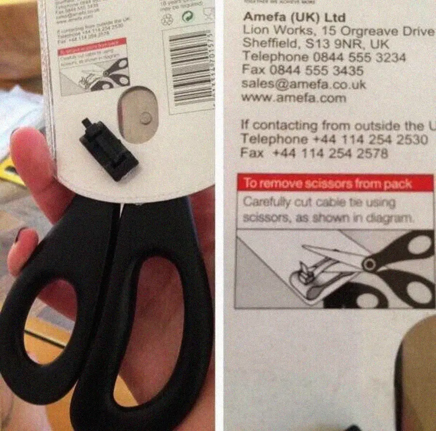 A hand holds scissors in packaging. The package instructions say to use scissors to cut the cable tie securing the scissors, illustrating the paradox with a diagram.