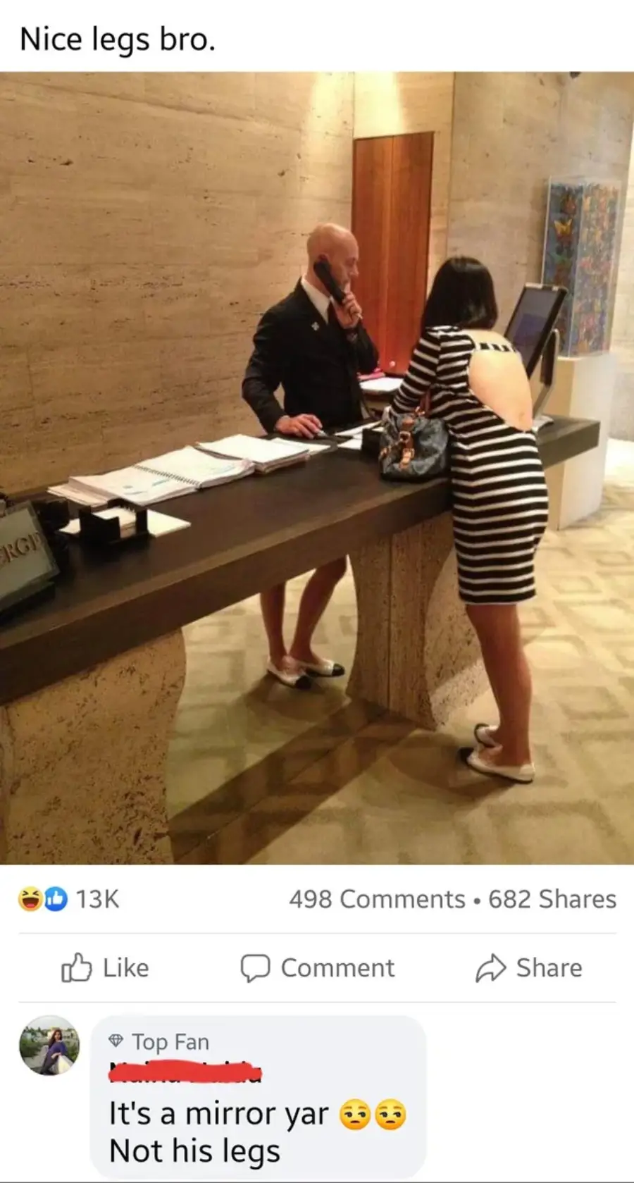 A man stands behind a hotel desk, appearing to have slim, bare legs due to a mirror reflecting a woman's legs as she leans on the counter in a striped dress. A comment below explains it's a mirror illusion, not his legs.