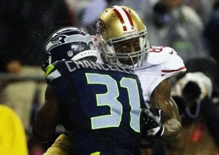 A football player from the Seattle Seahawks, wearing jersey number 31, tackles a player from the San Francisco 49ers during a game.
