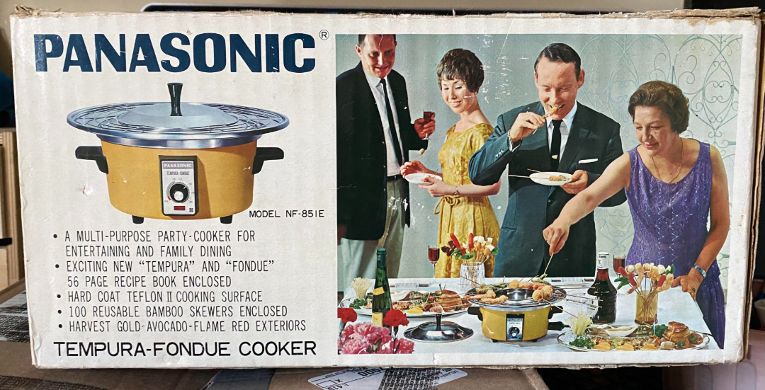 A vintage Panasonic tempura-fondue cooker box featuring a photo of four people in formal wear enjoying a meal around the cooker. Product features and specifications are listed on the left side of the box.