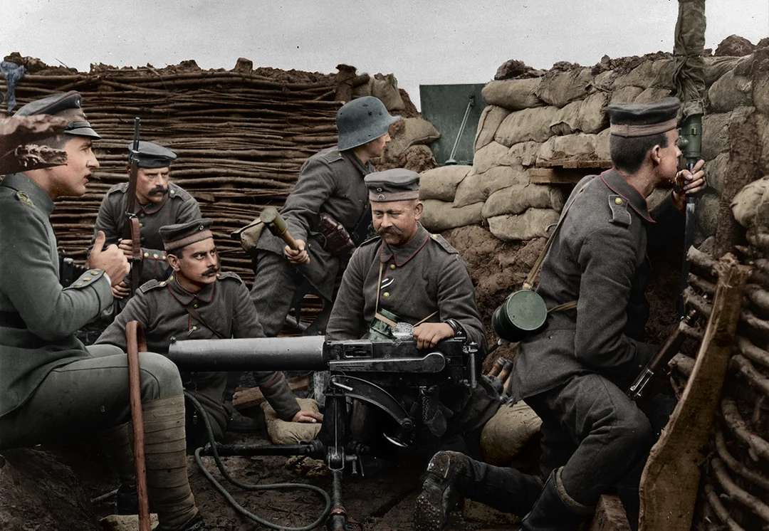 A group of World War I German soldiers in a trench operate a machine gun, surrounded by sandbags and wood, with one soldier aiming through a periscope and others preparing for combat.