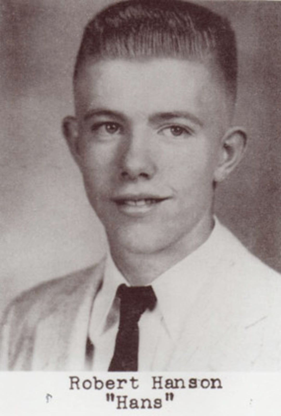 Black-and-white yearbook photo of a young man in a light suit, white shirt, and dark tie, with short hair. The name "Robert Hanson 'Hans'" is printed below the image.